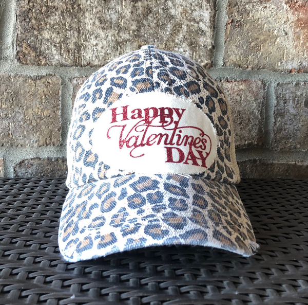 Leopard print cap with 'Happy Valentine's Day' text on a brick background