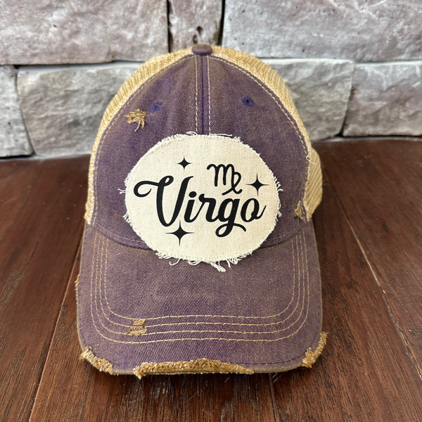 Cap with 'Me Virgo' logo on a wooden surface and stone wall background
