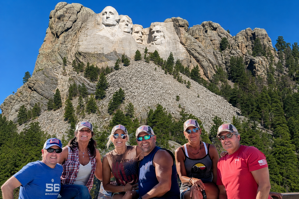 Group wearing BohoGroove American flag distressed trucker hats at Mount Rushmore in South Dakota