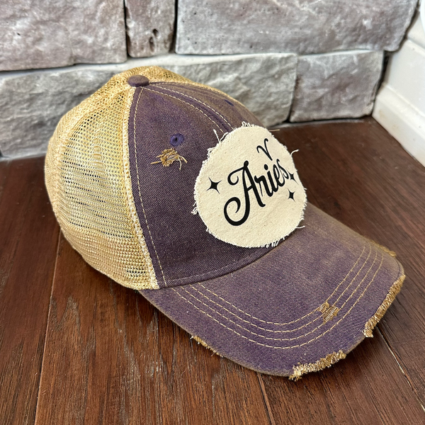 Aries hat by BohoGroove with black Aries lettering and constellation graphic on a distressed off-white custom patch on a purple vintage distressed snapback left side.