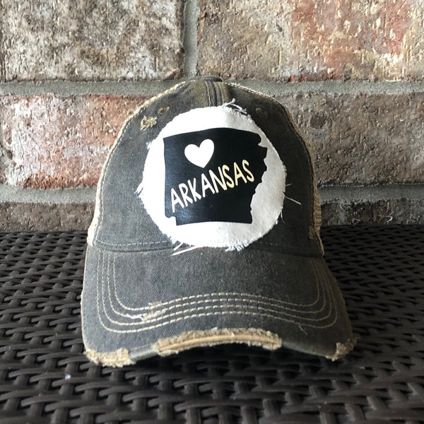 Arkansas hat by BohoGroove with black Arkansas state graphic and white heart on a distressed off-white custom patch on a black vintage distressed snapback trucker hat.
