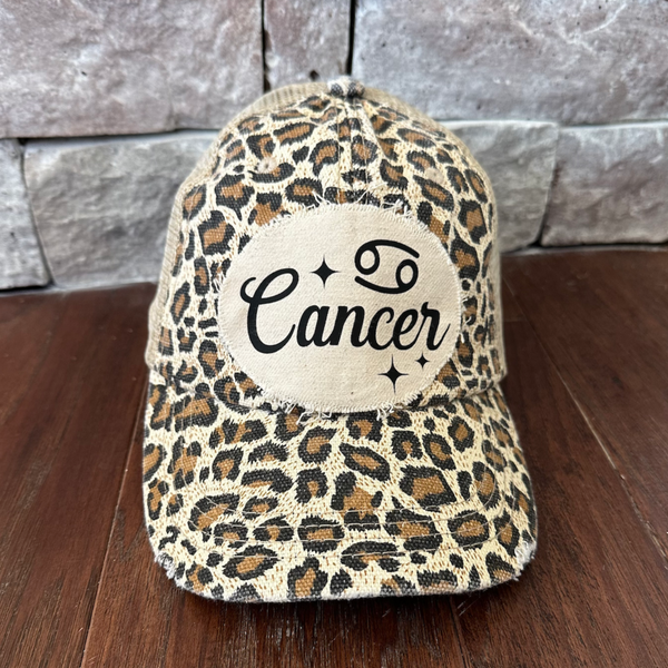 Cancer hat by BohoGroove with black Cancer lettering and constellation graphic on a distressed off-white custom patch on a leopard vintage distressed snapback.
