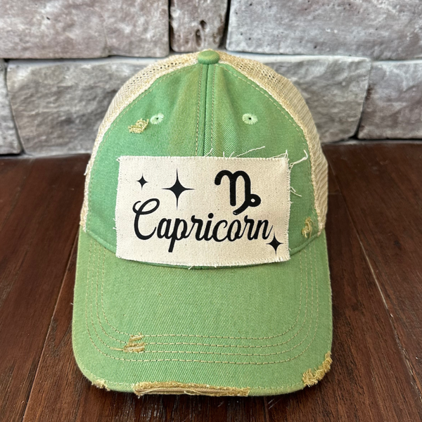 Capricorn hat by BohoGroove with black Capricorn lettering and constellation graphic on a distressed off-white custom patch on a mint vintage distressed snapback.