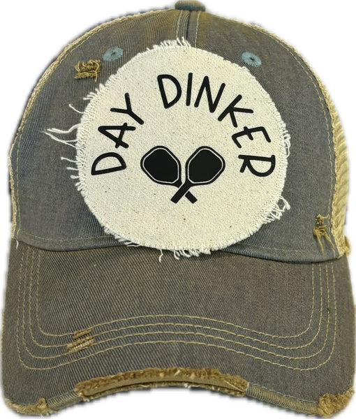 Day Dinker hat by BohoGroove featuring black Day Dinker lettering and crossed pickleball paddles graphic on a distressed off-white patch on a light blue vintage distressed snapback trucker hat.