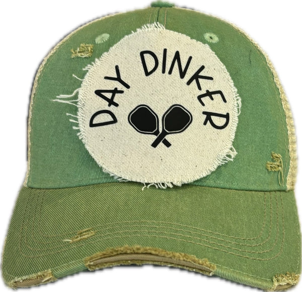 Day Dinker hat by BohoGroove featuring black Day Dinker lettering and crossed pickleball paddles graphic on a distressed off-white patch on a mint vintage distressed snapback trucker hat.