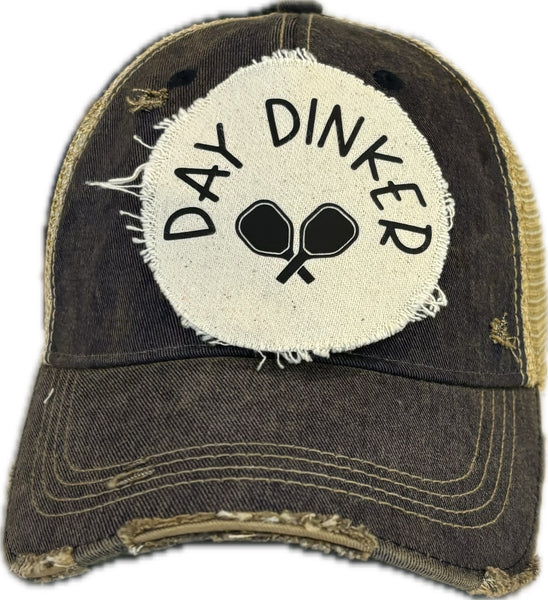 Day Dinker hat by BohoGroove featuring black Day Dinker lettering and crossed pickleball paddles graphic on a distressed off-white patch on a navy blue vintage distressed snapback trucker hat.