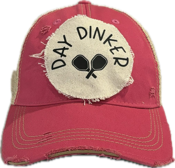 Day Dinker hat by BohoGroove featuring black Day Dinker lettering and crossed pickleball paddles graphic on a distressed off-white patch on a pink vintage distressed snapback trucker hat.