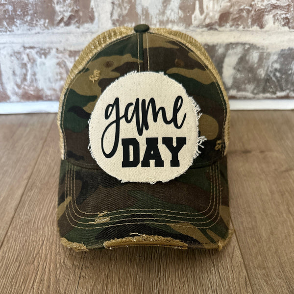 Game Day sports hat by BohoGroove with black Game Day lettering on distressed off-white patch on camo vintage distressed snapback.