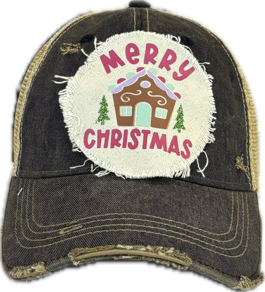 Gingerbread House hat by BohoGroove with pink Merry Christmas lettering, a gingerbread house graphic, and green trees on a distressed off-white patch on a navy blue vintage distressed snapback.