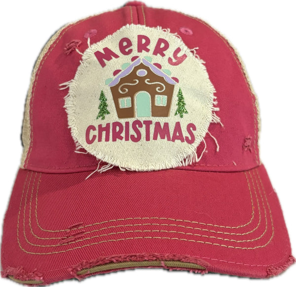 Gingerbread House hat by BohoGroove with pink Merry Christmas lettering, a gingerbread house graphic, and green trees on a distressed off-white patch on a pink vintage distressed snapback.