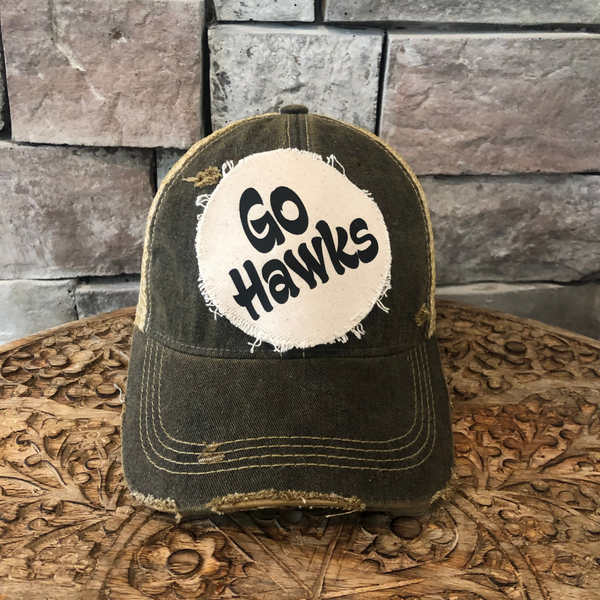 Go Hawks hat by BohoGroove featuring black Go Hawks lettering on a round cream frayed patch on a black vintage distressed snapback trucker hat.