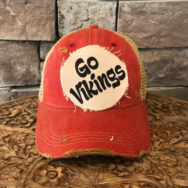Go Vikings hat by BohoGroove featuring black Go Vikings lettering on a round cream frayed patch on a red vintage distressed snapback trucker hat.