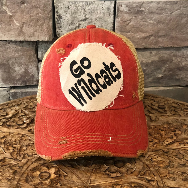 Go Wildcats hat by BohoGroove featuring black Go Wildcats lettering on a round cream frayed patch on a  red vintage distressed snapback trucker hat.