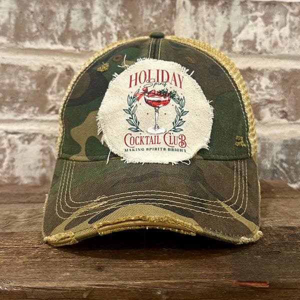 Holiday Cocktail Club hat by BohoGroove featuring a festive cocktail and Making Spirits Bright design on a Camo vintage distressed snapback trucker hat.