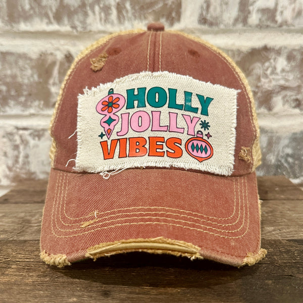Holly Jolly Vibes hat by BohoGroove featuring a colorful retro Christmas design on a brick red vintage distressed snapback trucker hat.