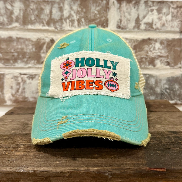 Holly Jolly Vibes hat by BohoGroove featuring a colorful retro Christmas design on an ocean blue vintage distressed snapback trucker hat.