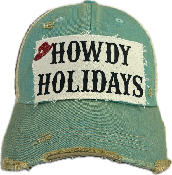 Howdy Holidays Cowboy Hat by BohoGroove with black Howdy Holidays lettering and a red glitter cowboy hat graphic on a distressed off-white custom patch on an ocean blue vintage distressed snapback.