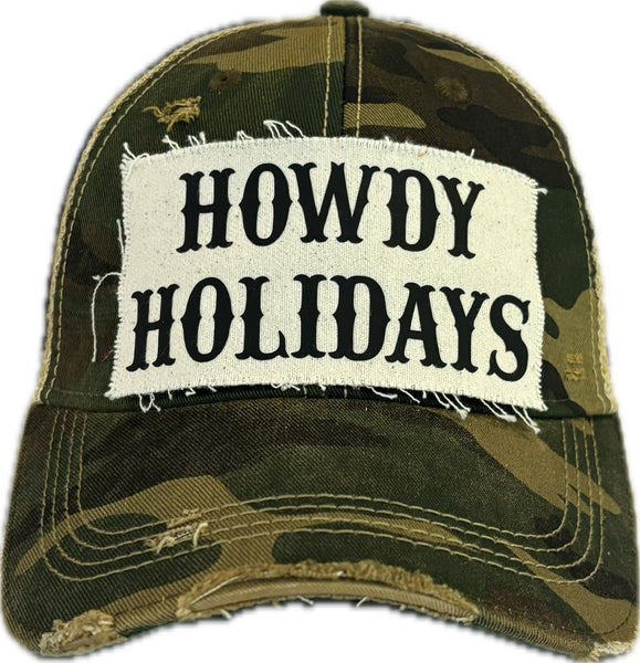 Howdy Holidays hat by BohoGroove with black Howdy Holidays lettering on a distressed off-white custom patch on a camo vintage distressed snapback.