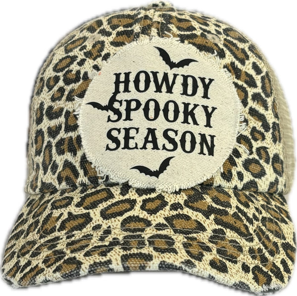 Howdy Spooky Season hat by BohoGroove with black wording and bat graphics on a distressed off-white patch on a leopard vintage distressed snapback trucker hat.