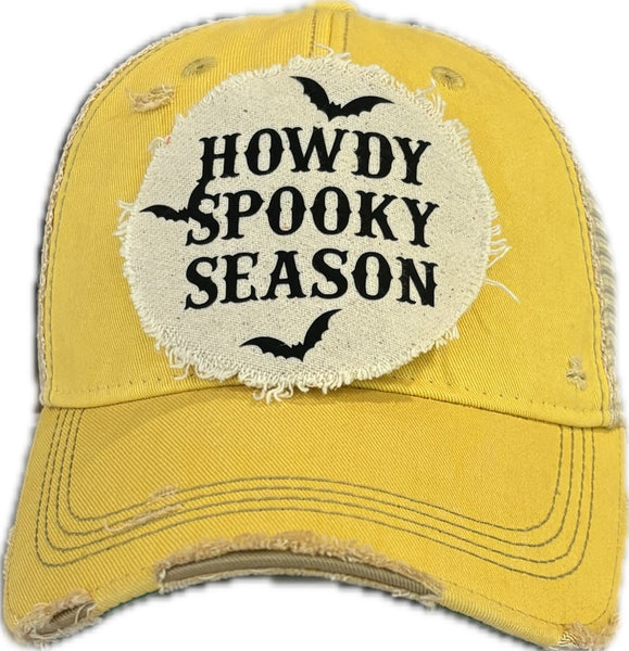 Howdy Spooky Season hat by BohoGroove with black wording and bat graphics on a distressed off-white patch on a yellow vintage distressed snapback trucker hat.
