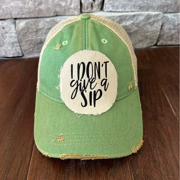 I Don't Give a Sip hat by BohoGroove featuring a funny drinking saying patch on a mint green vintage distressed snapback trucker hat.