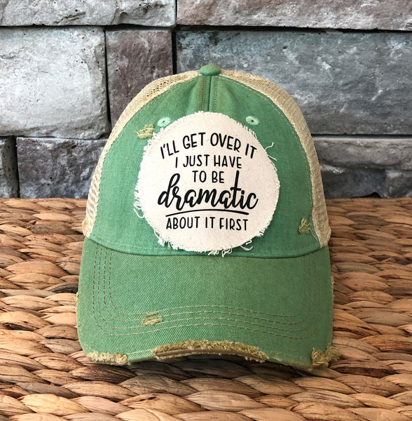 I’ll Get Over It I Just Have to Be Dramatic First hat by BohoGroove with black lettering on a distressed off-white patch on a mint vintage distressed snapback.