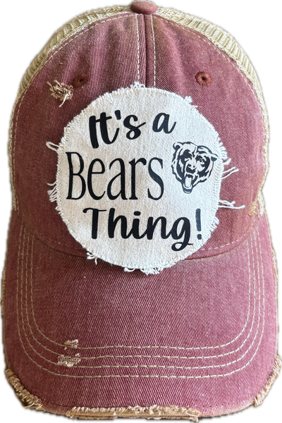 It's a Bear Thing hat by BohoGroove featuring black lettering and  bear graphic on a round cream frayed patch on a brick red vintage distressed snapback trucker hat.