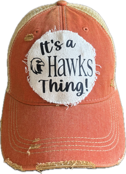 It's a Hawks Thing hat by BohoGroove featuring black lettering and a hawk graphic on a round cream frayed patch on an orange vintage distressed snapback trucker hat.