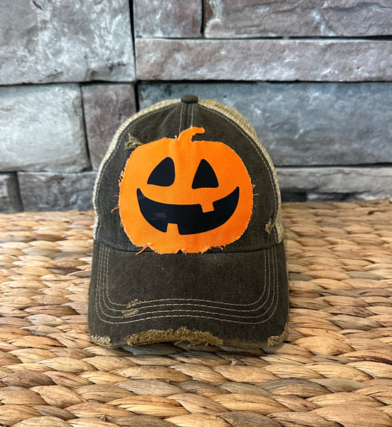 Jack-o’-Lantern hat by BohoGroove with orange pumpkin face design on a black vintage distressed snapback trucker hat.
