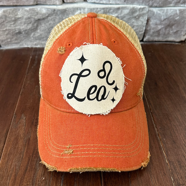 Leo hat by BohoGroove with black Leo lettering and constellation graphic on a distressed off-white custom patch on an orange vintage distressed snapback.
