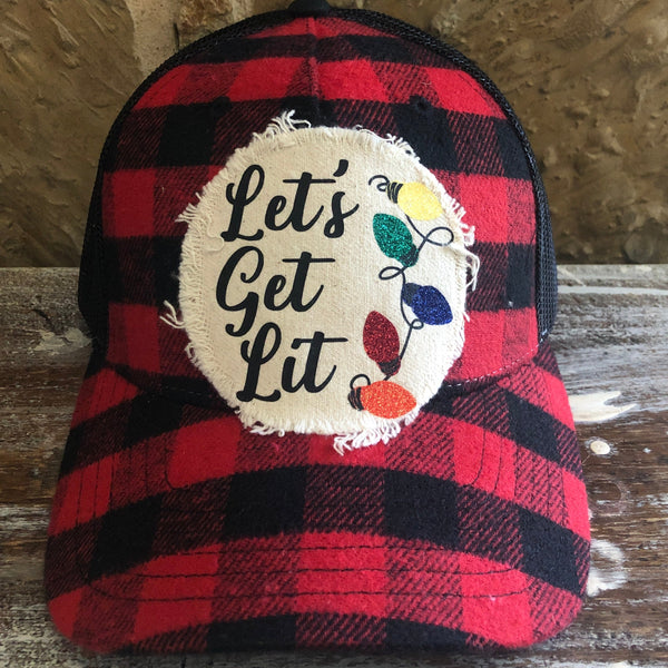 Let's Get Lit hat by BohoGroove with black Let's Get Lit lettering and multicolor glitter Christmas light graphics on a distressed off-white patch on a red and black buffalo plaid snapback trucker hat.
