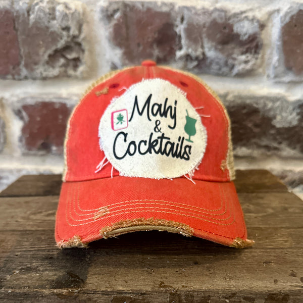 Mahj & Cocktails hat by BohoGroove featuring black Mahj & Cocktails lettering with a green cocktail graphic and Mahjong tile graphic on an off-white distressed patch on a red vintage distressed snapback trucker hat.