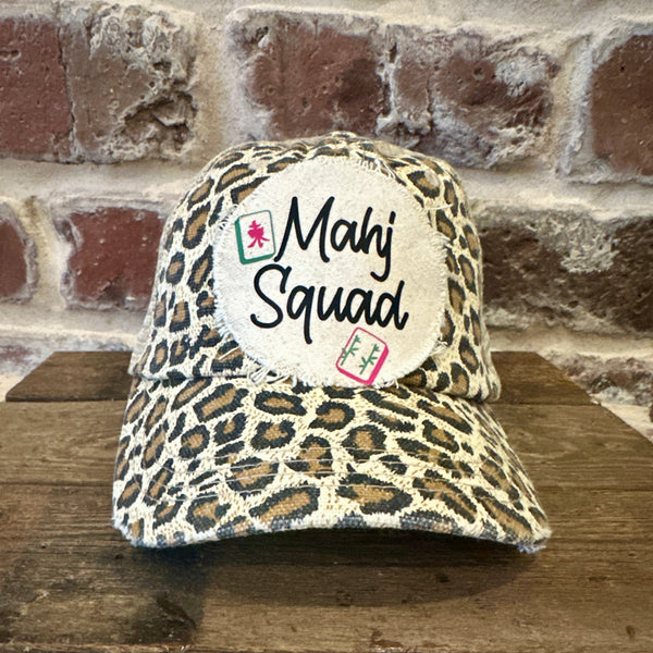 Mahj Squad hat by BohoGroove featuring black Mahj Squad lettering with Mahjong tile graphics on an off-white distressed patch on a leopard vintage distressed snapback trucker hat.