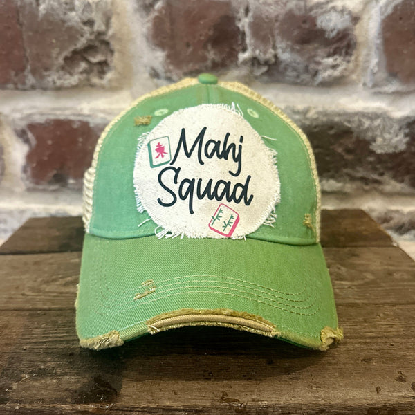 Mahj Squad hat by BohoGroove featuring black Mahj Squad lettering with Mahjong tile graphics on an off-white distressed patch on a mint vintage distressed snapback trucker hat.