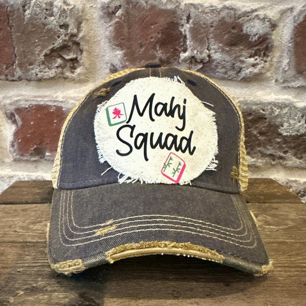 Mahj Squad hat by BohoGroove featuring black Mahj Squad lettering with Mahjong tile graphics on an off-white distressed patch on a navy vintage distressed snapback trucker hat.
