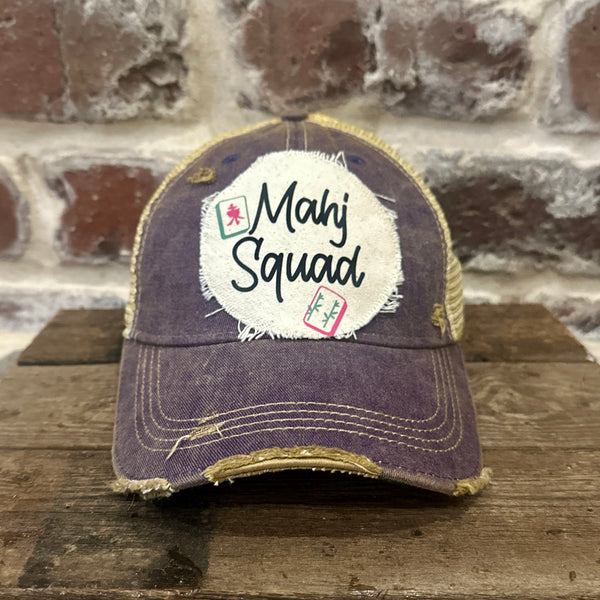 Mahj Squad hat by BohoGroove featuring black Mahj Squad lettering with Mahjong tile graphics on an off-white distressed patch on a purple vintage distressed snapback trucker hat.