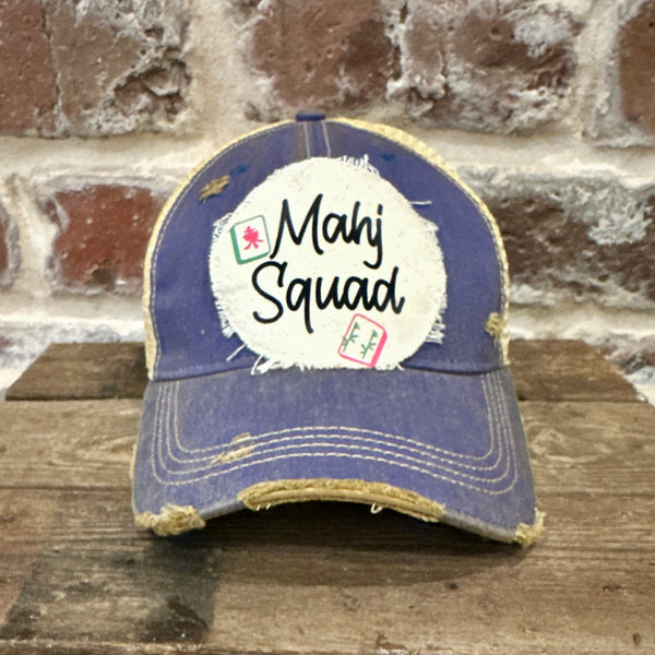 Mahj Squad hat by BohoGroove featuring black Mahj Squad lettering with Mahjong tile graphics on an off-white distressed patch on a royal vintage distressed snapback trucker hat.