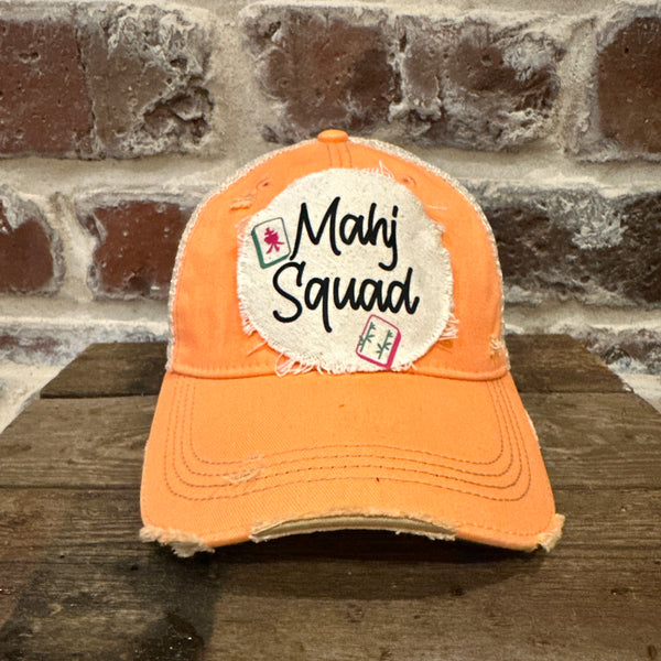 Mahj Squad hat by BohoGroove featuring black Mahj Squad lettering with Mahjong tile graphics on an off-white distressed patch on a sherbet vintage distressed snapback trucker hat.