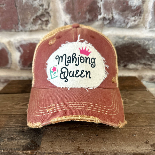 Mahjong Queen hat by BohoGroove featuring black Mahjong Queen lettering with a pink crown and Mahjong tile graphic on an off-white distressed patch on a brick red vintage distressed snapback trucker hat.