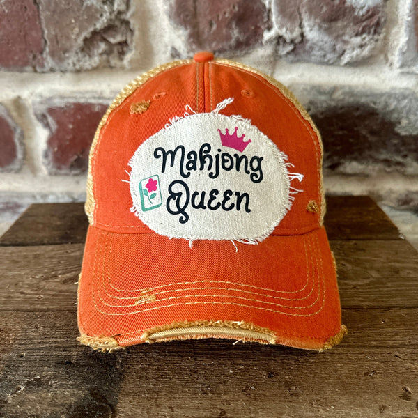 Mahjong Queen hat by BohoGroove featuring black Mahjong Queen lettering with a pink crown and Mahjong tile graphic on an off-white distressed patch on an orange vintage distressed snapback trucker hat.