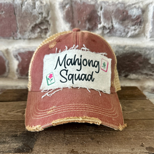 Mahjong Squad hat by BohoGroove featuring black Mahjong Squad lettering with Mahjong tile graphics on an off-white distressed patch on a brick red vintage distressed snapback trucker hat.