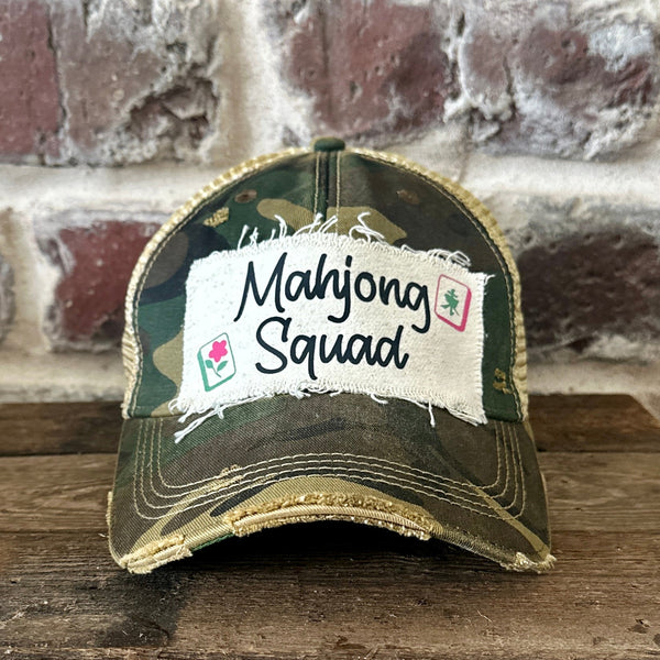 Mahjong Squad hat by BohoGroove featuring black Mahjong Squad lettering with Mahjong tile graphics on an off-white distressed patch on a camo vintage distressed snapback trucker hat.