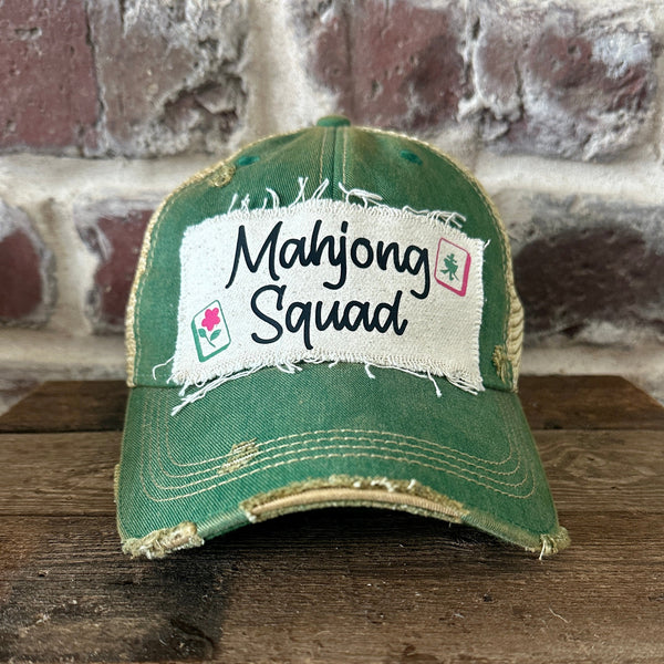 Mahjong Squad hat by BohoGroove featuring black Mahjong Squad lettering with Mahjong tile graphics on an off-white distressed patch on a green vintage distressed snapback trucker hat.