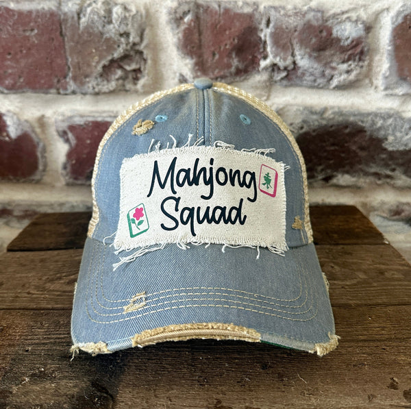 Mahjong Squad hat by BohoGroove featuring black Mahjong Squad lettering with Mahjong tile graphics on an off-white distressed patch on a light blue vintage distressed snapback trucker hat.