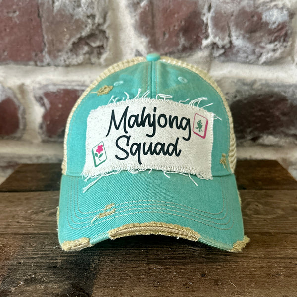 Mahjong Squad hat by BohoGroove featuring black Mahjong Squad lettering with Mahjong tile graphics on an off-white distressed patch on an ocean blue vintage distressed snapback trucker hat.