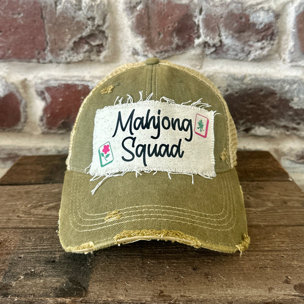 Mahjong Squad hat by BohoGroove featuring black Mahjong Squad lettering with Mahjong tile graphics on an off-white distressed patch on an olive vintage distressed snapback trucker hat.