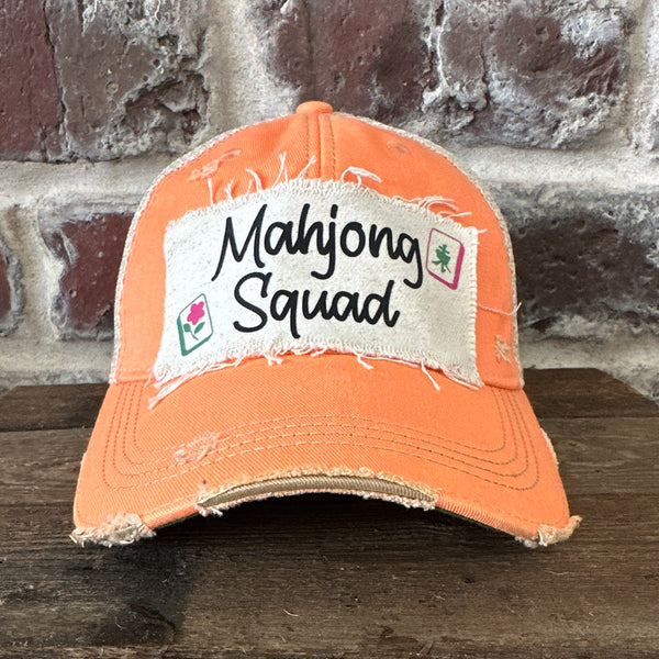 Mahjong Squad hat by BohoGroove featuring black Mahjong Squad lettering with Mahjong tile graphics on an off-white distressed patch on a sherbet vintage distressed snapback trucker hat.