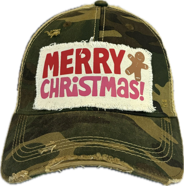 Merry Christmas Gingerbread hat by BohoGroove with red and pink Merry Christmas lettering and a gingerbread man graphic on a distressed off-white custom patch on a camo vintage distressed snapback.