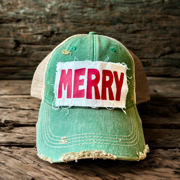 Merry hat by BohoGroove with pink and red Merry lettering on a distressed off-white rectangular custom patch on a green vintage distressed snapback.