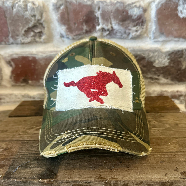 Mustang Pony Glitter Hat by BohoGroove with a red glitter running pony on a distressed off-white patch on a camo vintage distressed snapback trucker hat.